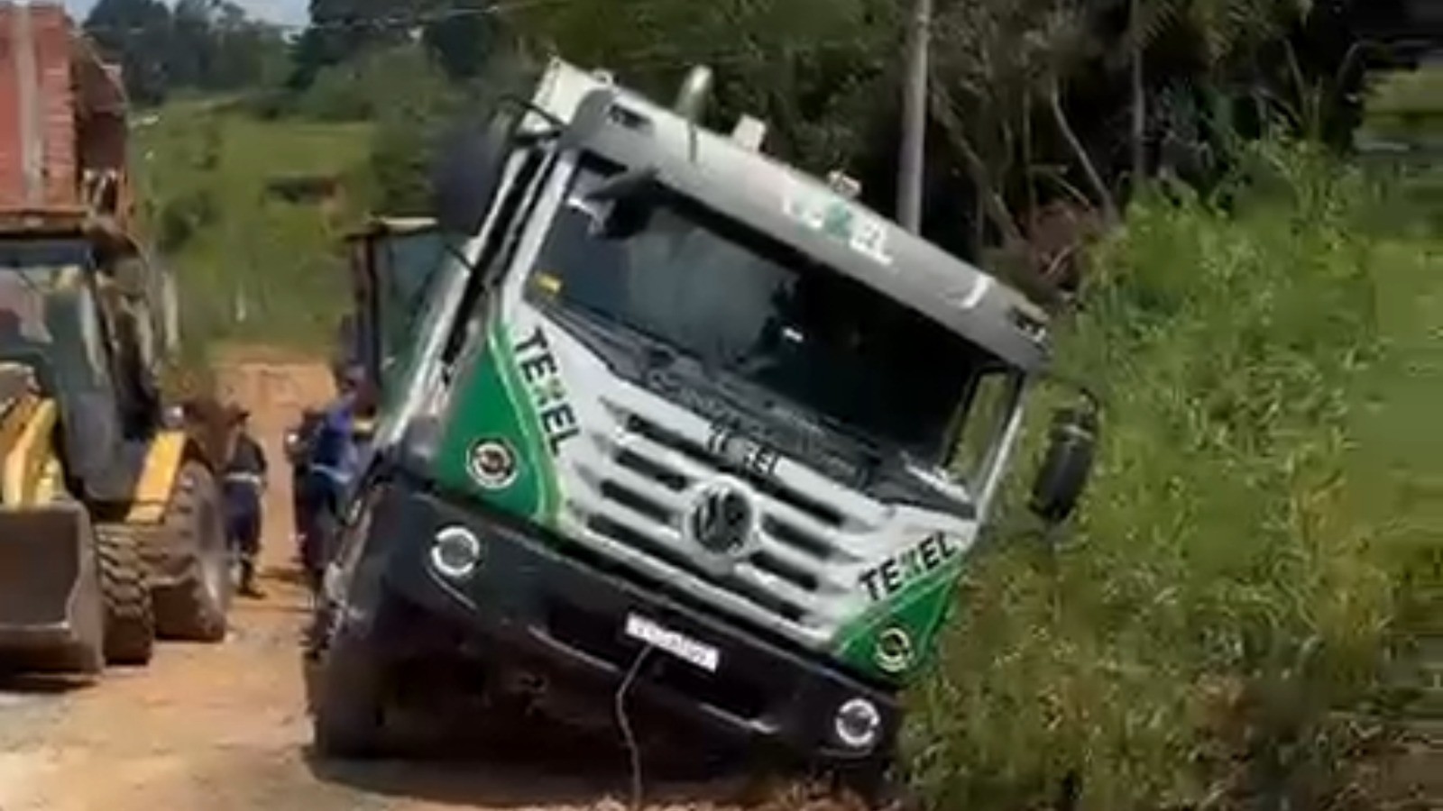 Caminhão de lixo cai em valeta e bloqueia rua em Poá