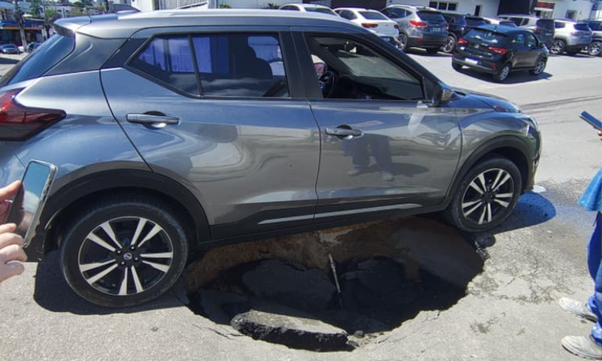 Carro fica preso em cratera após asfalto ceder no conjunto Vieiralves, em Manaus